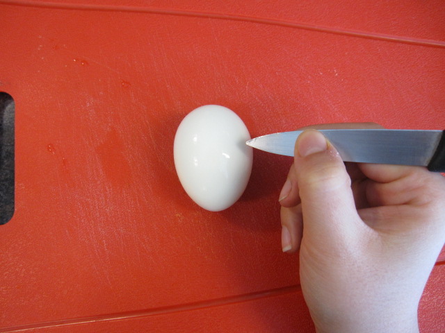 Ugotowane na twardo jajko przecinamy małym nożykiem, tworząc zygzak.