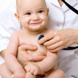young doctor with happy baby making examination