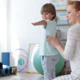 Gimnastyka korekcyjna - fizjoterapeutka ćwicząca z dzieckiem.